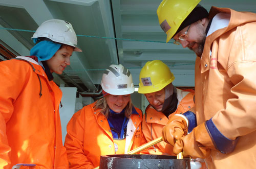 Scientists and technicians study a bottom sample.