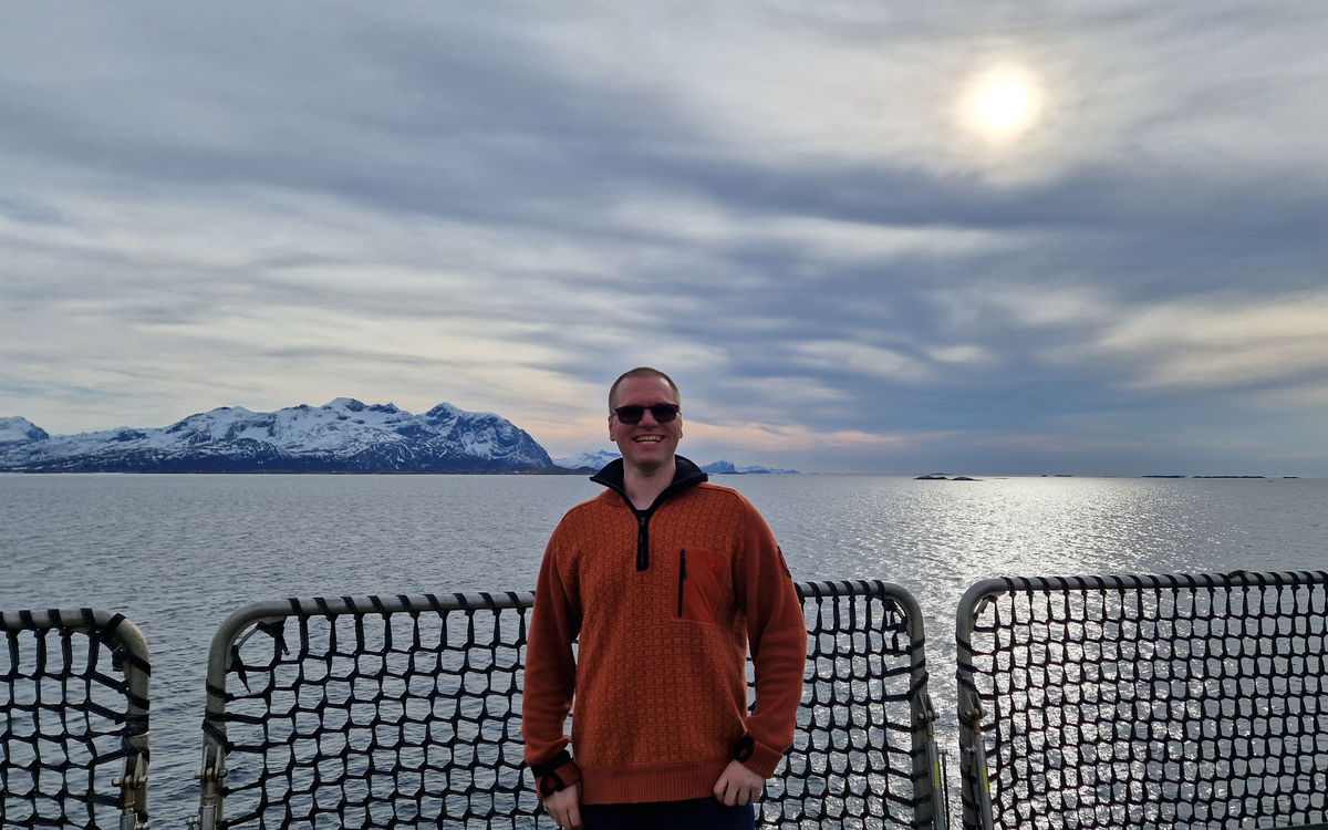 Daniel Wiberg smiler på en båt fra Tromsø.