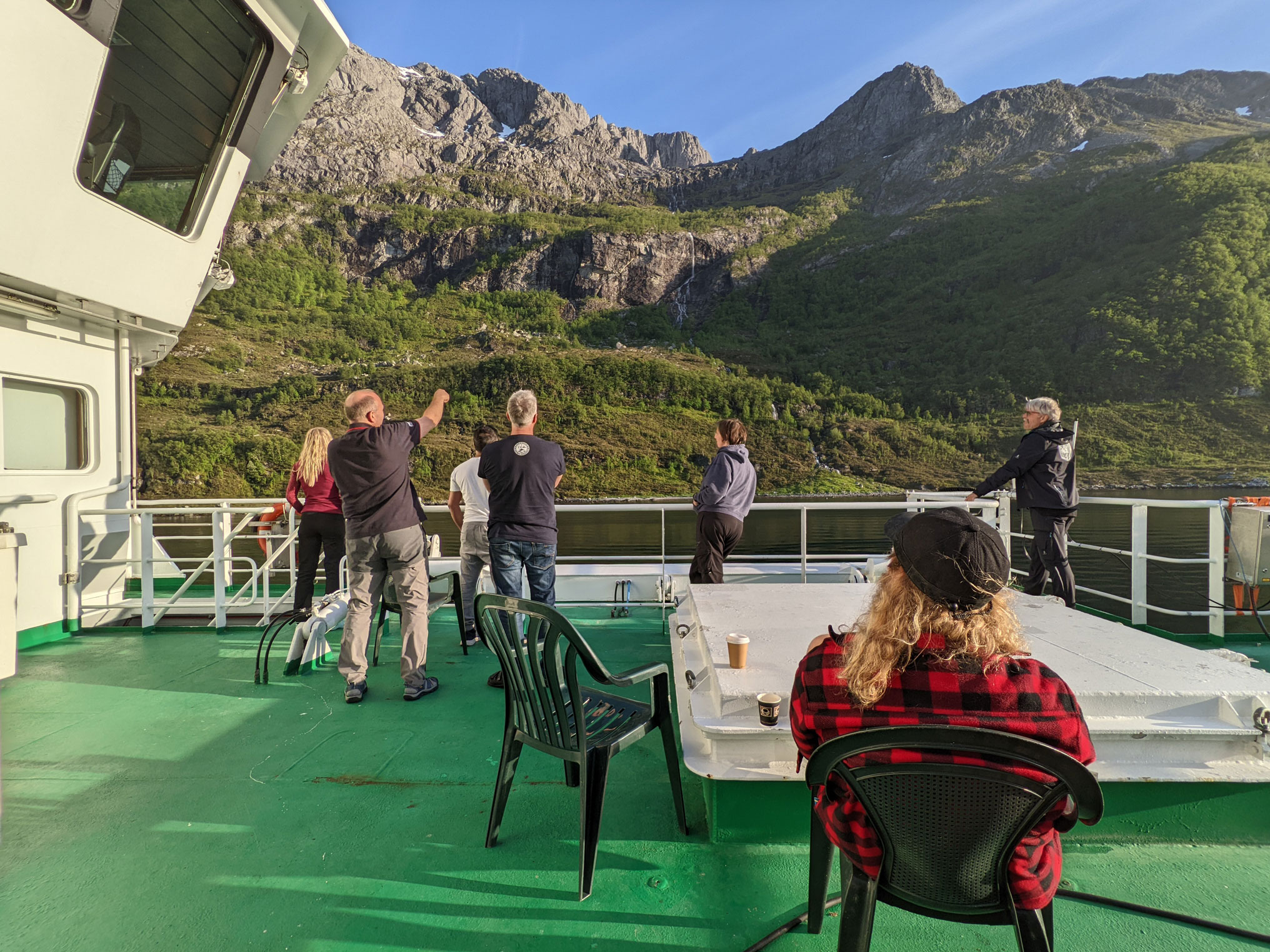 foto av personer på dekk som studerer fjellside