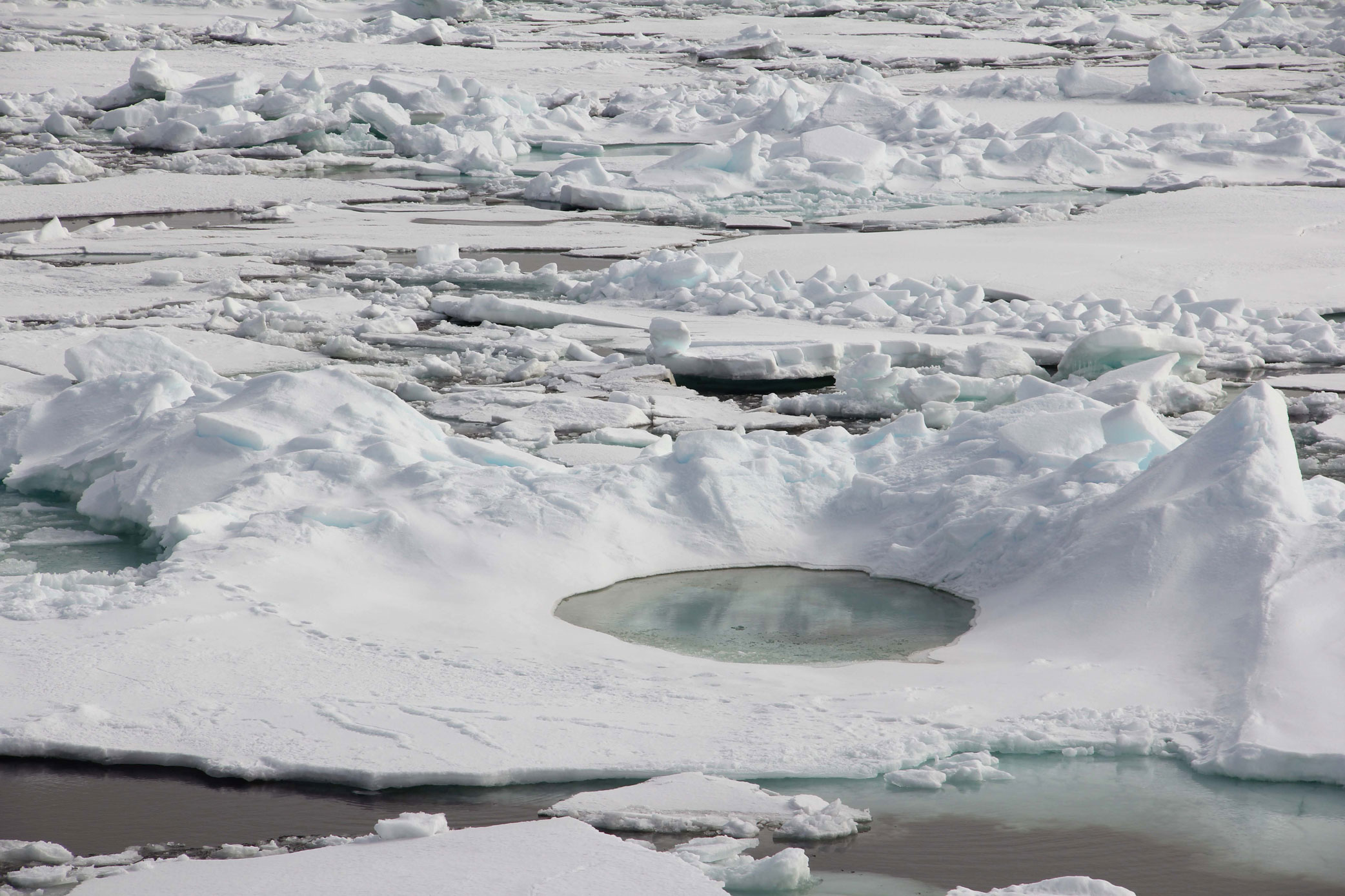 Bilde av is med et rundt basseng fyllt med vann.
