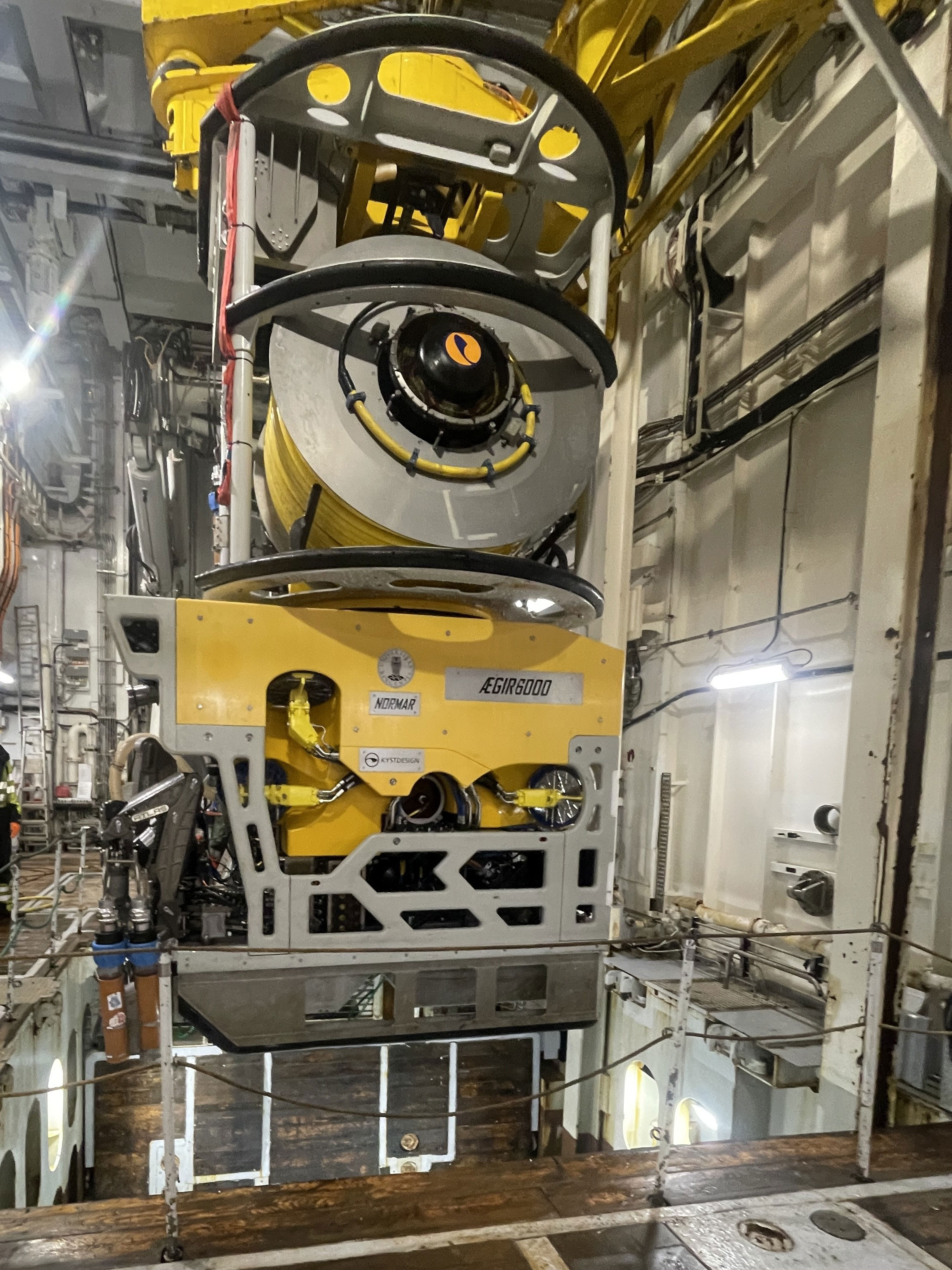 En slags avlang metallboks med ulike deler henger i luften..