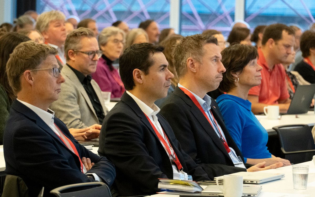 Nærbilde av fire personar som sit ved sidan av kvarandre og følger med på noko utanfor bildet.