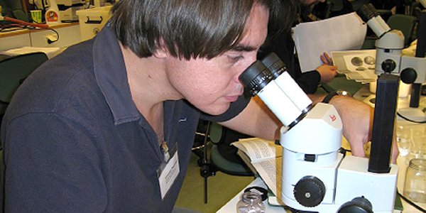 foto av mann som ser i mikroskop